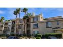 Multi-story apartment building with neutral stucco, dark trim, and palm tree landscaping at 7115 S Durango Dr # 208, Las Vegas, NV 89113