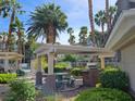 Outdoor grill area with shaded picnic seating and lush landscaping at 7115 S Durango Dr # 208, Las Vegas, NV 89113
