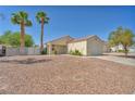 Exterior view of a single-story home with desert landscaping, tile roof, and an attached garage at 719 Roberta Alecia Ave, North Las Vegas, NV 89031