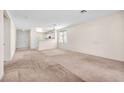 Open-concept living room with neutral carpet and a view into the kitchen area at 719 Roberta Alecia Ave, North Las Vegas, NV 89031
