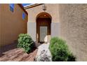 Inviting front entrance with arched entry and desert landscaping leading to the front door at 7613 Pulpit Rock Ct, Las Vegas, NV 89166