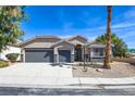 Charming single-story home featuring a three-car garage, desert landscaping, and a well-manicured front yard at 8080 Black Orchid Ave, Las Vegas, NV 89131