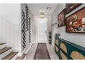 Stylish entryway with decorative wall art, a modern light fixture, and a convenient shoe rack offers a welcoming ambiance at 813 Bluebird Hill Ave, North Las Vegas, NV 89084