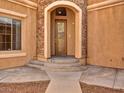 Elegant front entrance with a stone archway and a decorative glass door at 8267 Campbell Springs Ave, Las Vegas, NV 89178