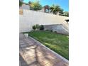 The backyard shows a grassy lawn, brick-lined flowerbeds, and a concrete block fence at 8328 Cimarron Ridge Dr, Las Vegas, NV 89128
