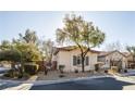 Street view of a cozy house with mature trees and an inviting curb appeal at 9077 Creed Mountain Pl, Las Vegas, NV 89178