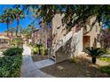 Attractive condo exterior with lush landscaping, sidewalk, and stairs to the front door at 9325 W Desert Inn Rd # 143, Las Vegas, NV 89117