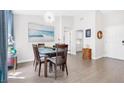 Bright dining area with a glass table, six chairs and modern light fixture at 9445 Grand Mesa Dr, Las Vegas, NV 89134