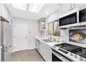 Modern kitchen boasting stainless steel appliances, white cabinets, and skylight at 9445 Grand Mesa Dr, Las Vegas, NV 89134