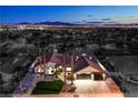 Dramatic aerial view of a well-maintained home, lush landscaping, and vibrant city skyline at dusk at 1144 Calico Ridge Dr, Henderson, NV 89011
