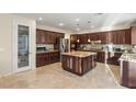 A spacious kitchen with dark wood cabinetry, granite countertops, a center island, and stainless steel appliances at 1265 Vietti St, Henderson, NV 89012
