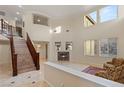 Bright and airy living room with large windows, a fireplace, and staircase at 1265 Vietti St, Henderson, NV 89012