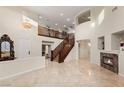 Open-concept living room with a staircase, fireplace, beautiful chandelier, and lots of natural light at 1265 Vietti St, Henderson, NV 89012
