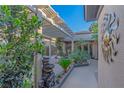 Picturesque courtyard featuring a pergola, lush greenery, stone accents, and decorative art at 17 Chatmoss Rd, Henderson, NV 89052