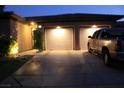 Nighttime view of the home's front exterior, driveway, and illuminated garage doors at 17 Chatmoss Rd, Henderson, NV 89052