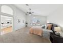Spacious main bedroom with high ceilings, ceiling fan, carpet flooring, and adjoining ensuite bathroom at 1707 Navarre Ln, Henderson, NV 89014