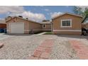 A tan single story home features desert landscaping and an attached garage at 1911 Venalynne St, Las Vegas, NV 89156
