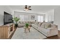 Spacious living room featuring a large sectional couch, modern fan and neutral decor at 2885 Timber Country Rd, North Las Vegas, NV 89086
