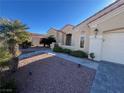 Lovely home with a desert landscaped front yard with pathway to covered entry and attached garage under clear blue skies at 3004 Darby Falls Dr, Las Vegas, NV 89134