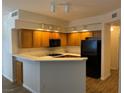 Efficient kitchen with wood cabinets, a gas cooktop, and a breakfast bar at 311 Manti Pl # 311, Henderson, NV 89014