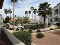Exterior view of the property showcasing the walking path, palm trees, and well-maintained landscaping at 3125 N Buffalo Dr # 1080, Las Vegas, NV 89128