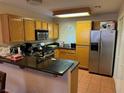 Well-lit kitchen with wooden cabinets, granite countertops, stainless steel appliances, and tile flooring at 3125 N Buffalo Dr # 1080, Las Vegas, NV 89128