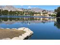 Scenic lake view showcasing the community buildings, palm trees, and mountains in the background on a sunny day at 3125 N Buffalo Dr # 1080, Las Vegas, NV 89128