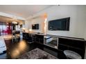Spacious bedroom with dark wood floors, mounted TVs, and modern shelving at 4381 W Flamingo Rd # 1212, Las Vegas, NV 89103