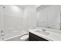 Bright bathroom featuring a shower-tub combo, white subway tile, and a vanity with a dark wood cabinet at 4510 E Brusca Way, Pahrump, NV 89061