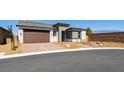 Charming single-story home with a brick driveway and a two-car garage, set against a clear blue sky at 4510 E Brusca Way, Pahrump, NV 89061