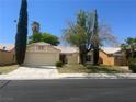 Inviting single-story home with a two car garage, desert landscaping, and mature trees in front yard at 4931 Crystal Breeze Ln, North Las Vegas, NV 89031