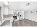 Updated kitchen features stainless steel appliances, white cabinets, grey backsplash, and modern finishes at 5120 Burnham Ave, Las Vegas, NV 89119