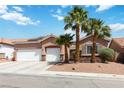 Attractive single-story home with a three-car garage and desert landscaping featuring palm trees at 7404 Dry Corral Ln, Las Vegas, NV 89113