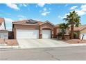 Inviting single-story home featuring a three-car garage, desert landscaping, and a tile roof at 7404 Dry Corral Ln, Las Vegas, NV 89113