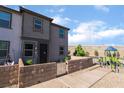 Two-story townhouse features a low brick wall, manicured front yard, and a community playground nearby at 756 Sleeping City Ave, Henderson, NV 89015