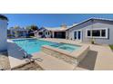 Beautiful backyard pool and spa, surrounded by a patio and an outdoor kitchen area at 7575 Coley Ave, Las Vegas, NV 89117