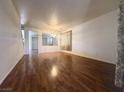 Bright and spacious living room featuring hardwood floors, neutral walls, and a decorative room divider at 7611 Avila Beach Ave, Las Vegas, NV 89113