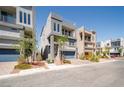 View of modern home with desert landscaping, two-car garage, and balcony at 8125 Monsoon Bay St, Las Vegas, NV 89113