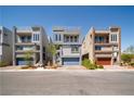 View of three modern homes with 2 stories, desert landscaping, and balconies at 8125 Monsoon Bay St, Las Vegas, NV 89113