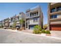 Street view of modern townhomes with desert landscaping and two-car garages at 8125 Monsoon Bay St, Las Vegas, NV 89113