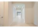Bright hallway with tile flooring leads to an open living space, showcasing modern design at 8732 Kendall Brook Cir, Las Vegas, NV 89149