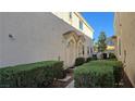 Side view of townhouse showcasing manicured bushes and dual entryways with covered porticos for added protection at 8811 Tomnitz Ave # 101, Las Vegas, NV 89178