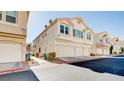 Exterior view of the townhome with attached garage, showing the well-maintained landscaping at 8811 Tomnitz Ave # 101, Las Vegas, NV 89178
