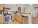 Bright kitchen featuring stainless steel appliances, light wood cabinets, and a decorative backsplash at 8811 Tomnitz Ave # 101, Las Vegas, NV 89178