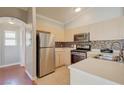 Well-lit kitchen features neutral cabinets, stainless steel appliances and a tile backsplash with a stainless sink at 8811 Tomnitz Ave # 101, Las Vegas, NV 89178