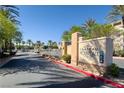 Entrance to the Chateau Nouveau community surrounded by lush palm trees and vibrant landscaping at 10001 Peace Way # 2228, Las Vegas, NV 89147