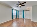 Bright living room with wood floors, a ceiling fan, and large windows with coverings at 1048 Painted Daisy Ave, Henderson, NV 89074