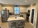 Bright kitchen featuring an island with quartz countertops and stainless steel appliances at 11257 Rainbow Peak Ave # 201, Las Vegas, NV 89135