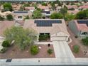 An aerial view of the home shows a tile roof with solar panels, a xeriscaped yard and a two car driveway at 2512 Desert Glen Dr, Las Vegas, NV 89134