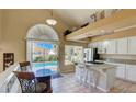 Bright kitchen featuring granite countertops, breakfast bar, white cabinetry, and poolside dining at 2714 Cricket Hollow Ct, Henderson, NV 89074